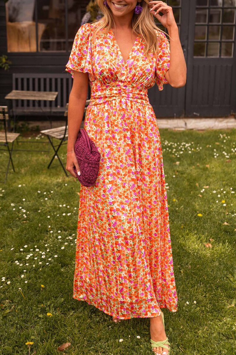 Woman in a colorful dress standing outdoors on grass