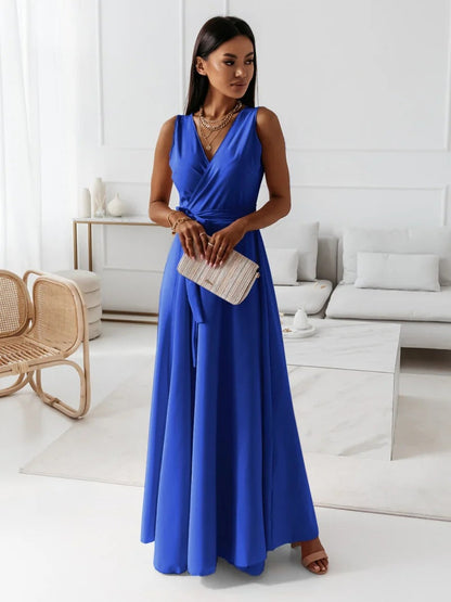 Woman in a blue dress holding a clutch in a modern living room.