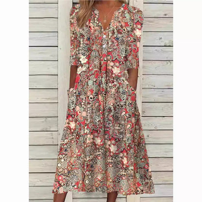 Woman wearing a floral dress standing against a wooden wall.