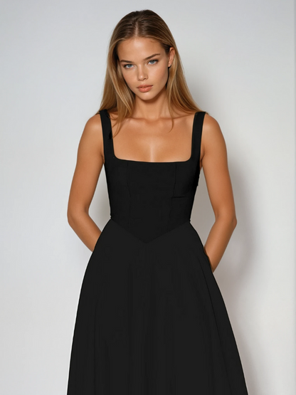 Woman wearing a black dress against a plain background