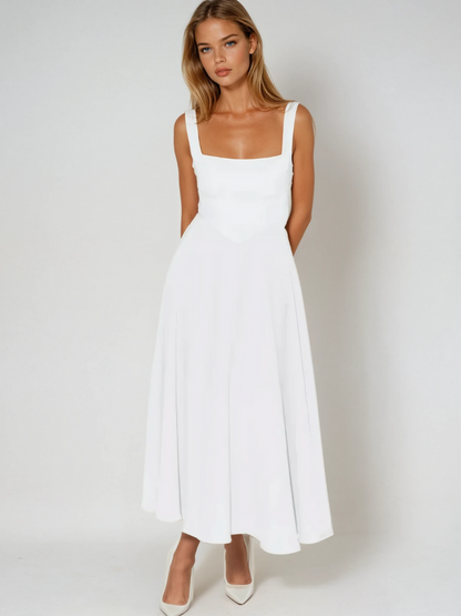 Woman wearing a white dress against a plain background