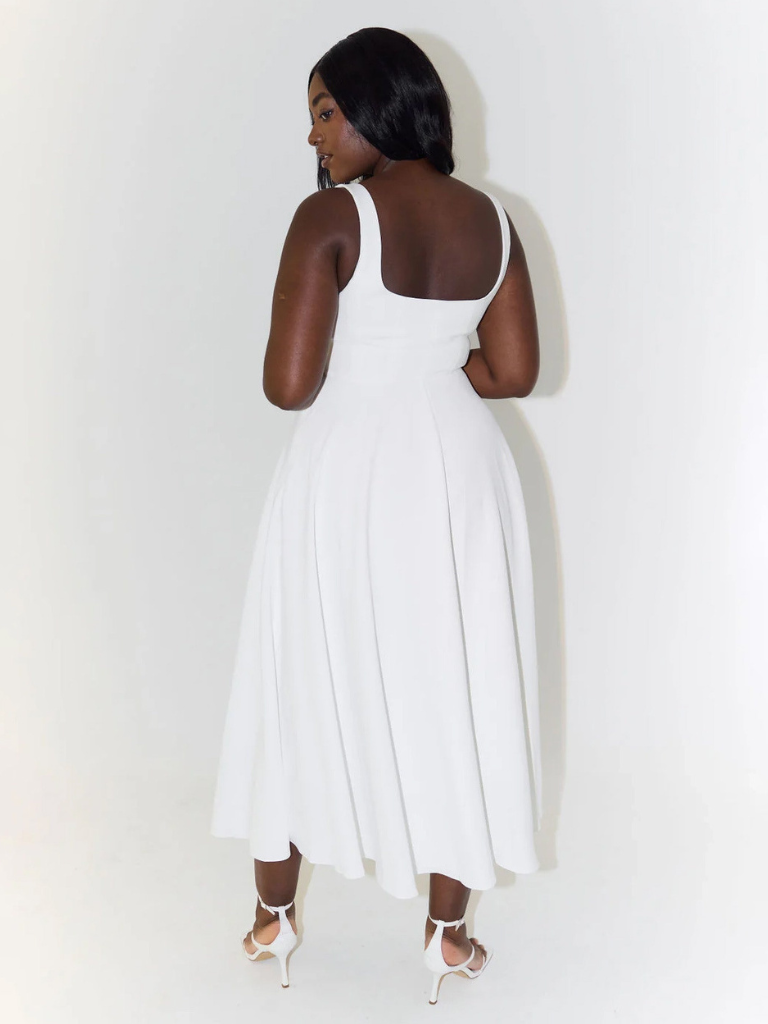 Woman wearing a white dress against a plain background