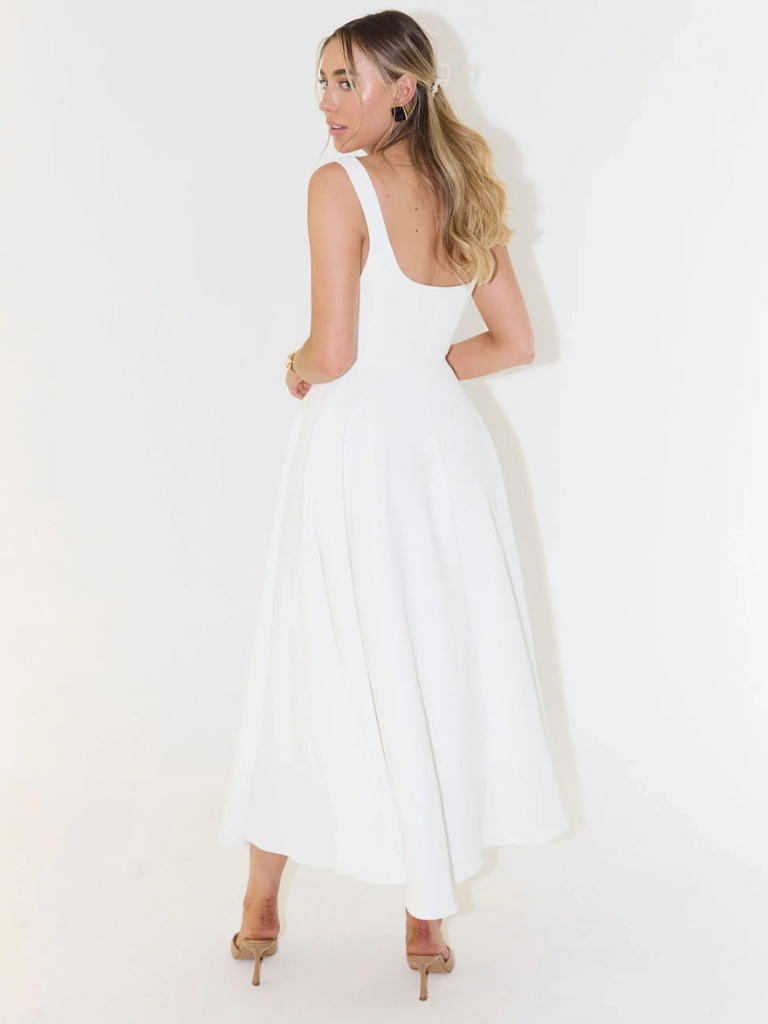 Woman wearing a white dress against a white background