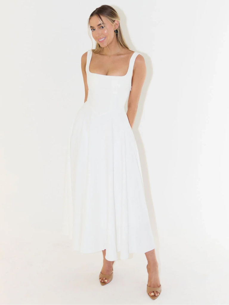 Woman wearing a white sleeveless dress on a plain background
