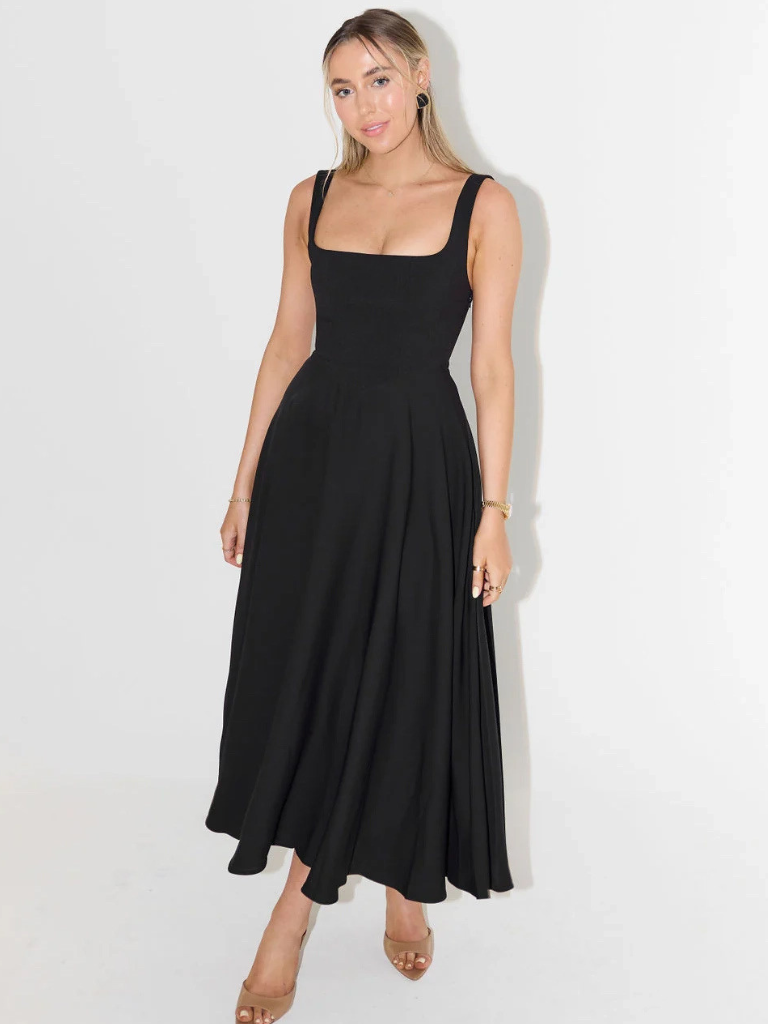 Woman wearing a black sleeveless dress against a white background