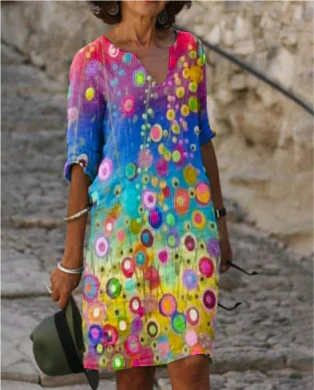Woman wearing a colorful dress with circular patterns on a stone path.
