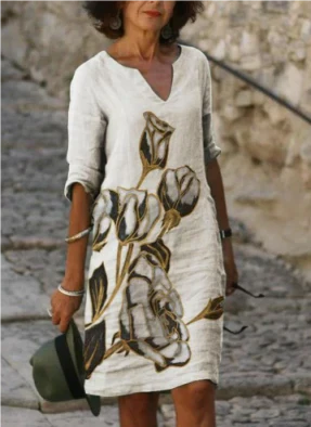 Woman wearing a floral dress with a stone wall background