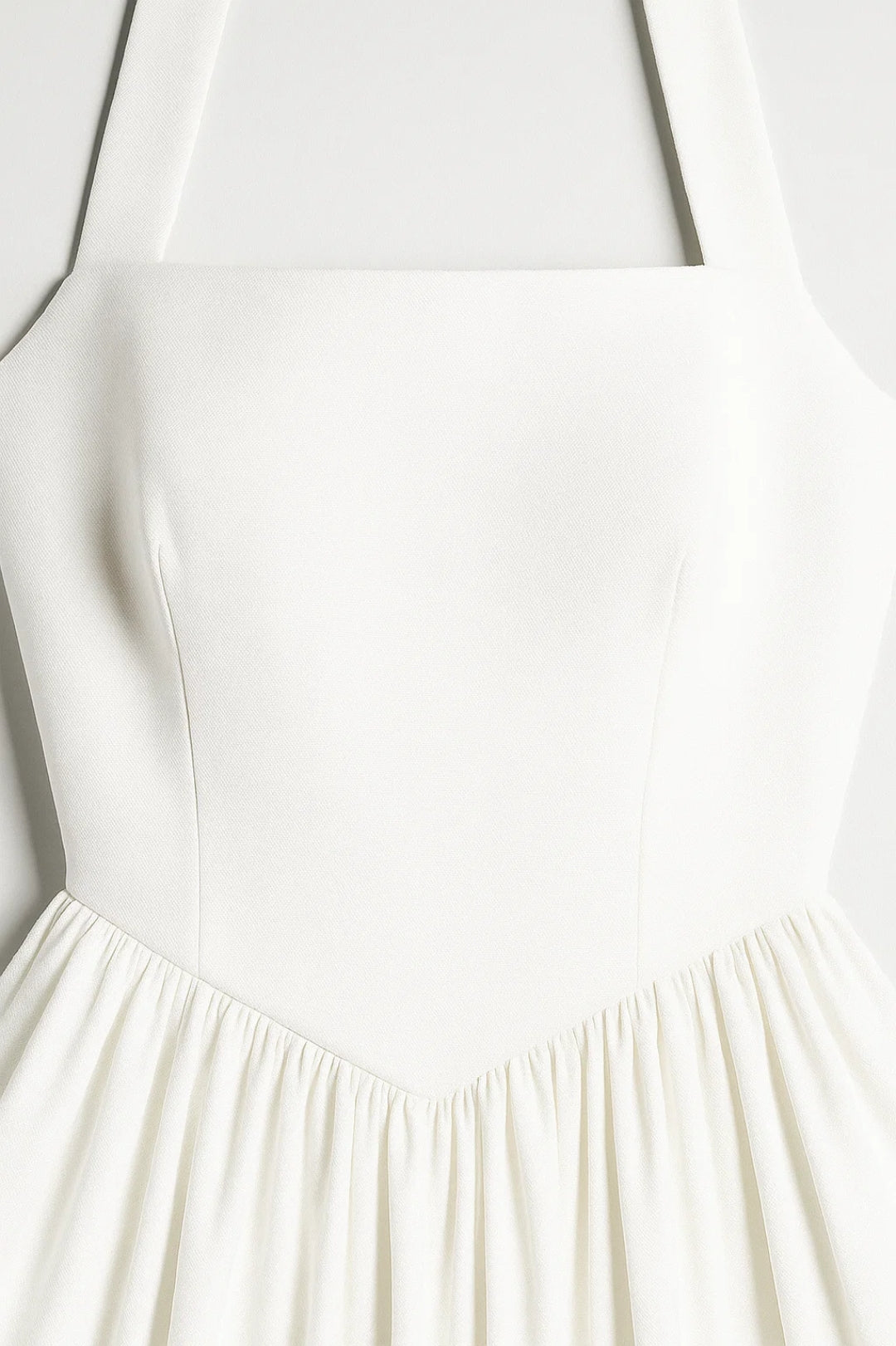 Close-up of a white dress with a fitted bodice and flowing skirt.