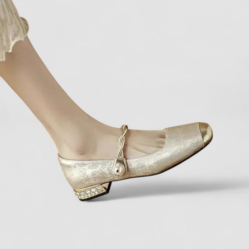 Gold high-heeled shoe on a light gray background