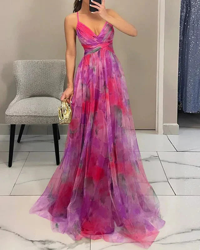 Woman wearing a colorful evening gown in a room with a chair and mirror.