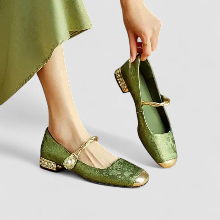 Green shoes with gold accents worn by a person, on a light gray background