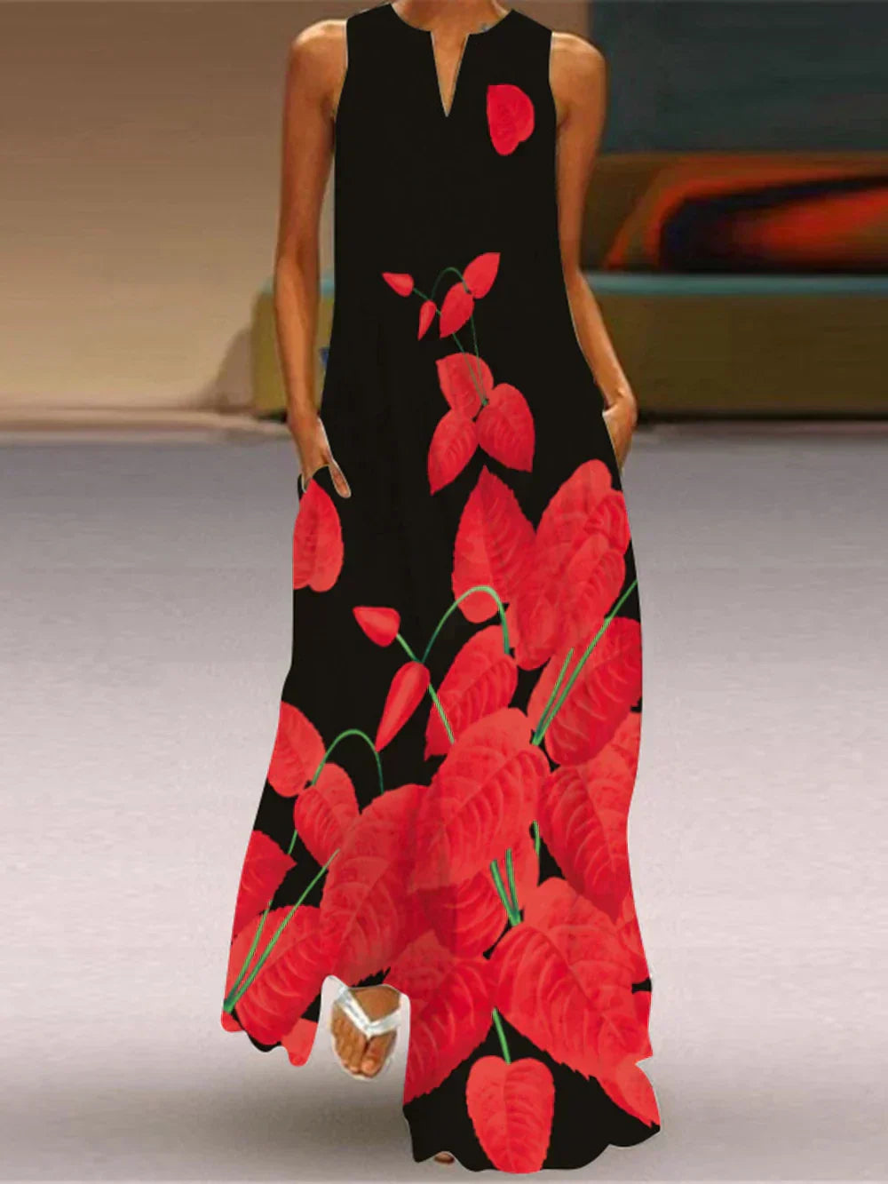 Black dress with red floral pattern worn by a person indoors.
