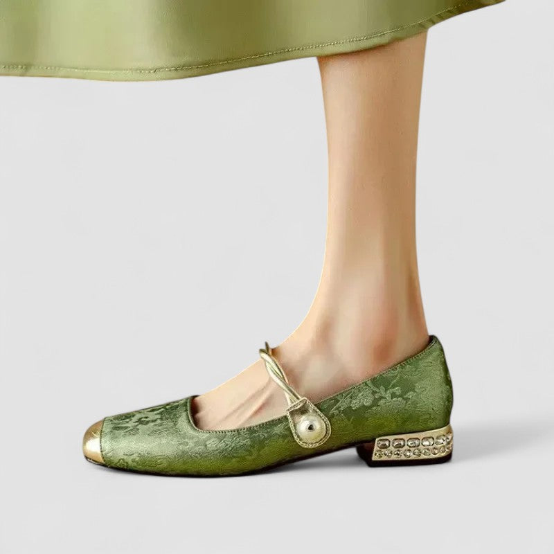 Green flat shoe with decorative elements on a light gray background
