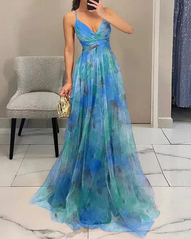 Woman wearing a blue and green floral evening gown in a room.
