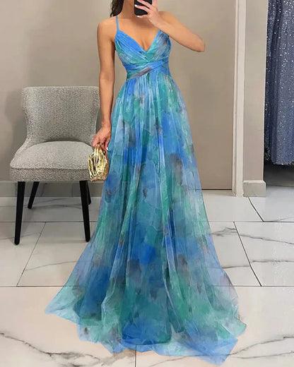 Woman wearing a blue and green floral evening gown in a room.