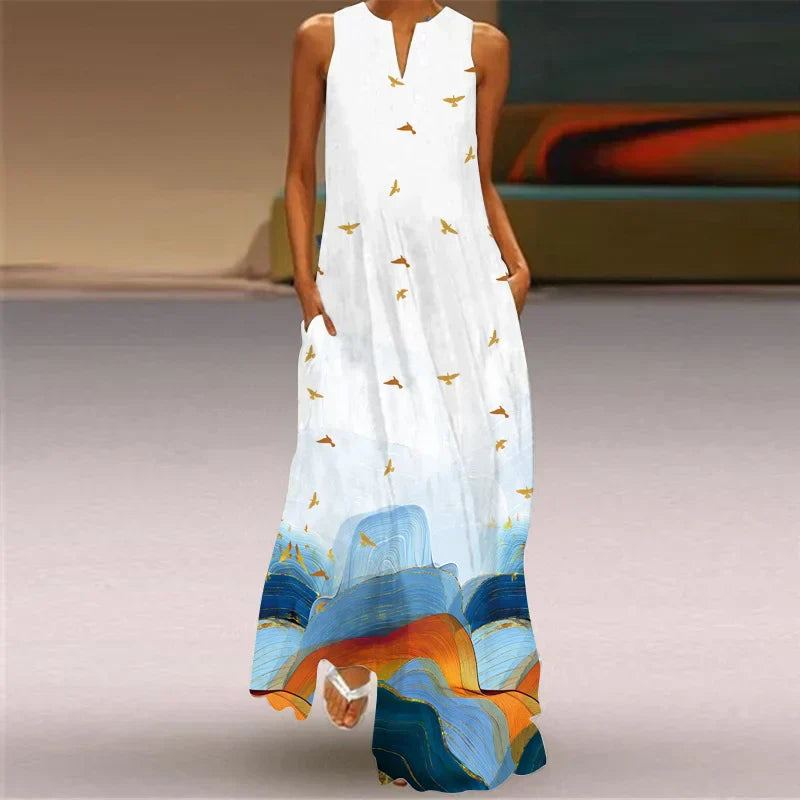 Woman wearing a long, white dress with colorful abstract patterns and bird designs.