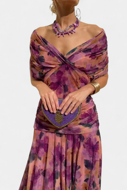 Woman wearing a floral dress with a purple clutch against a white background