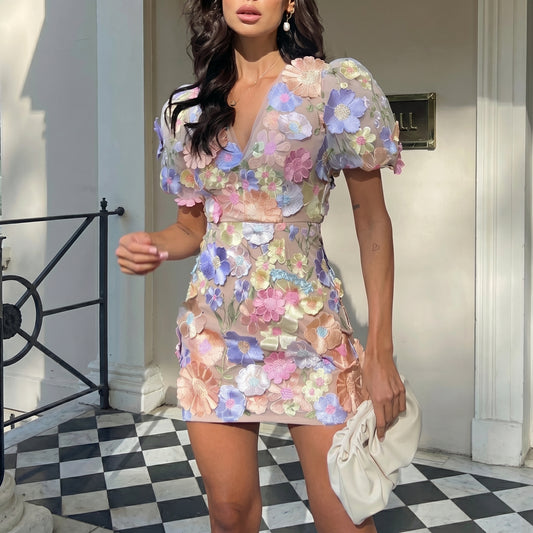 Woman wearing a floral dress standing on a checkered floor.
