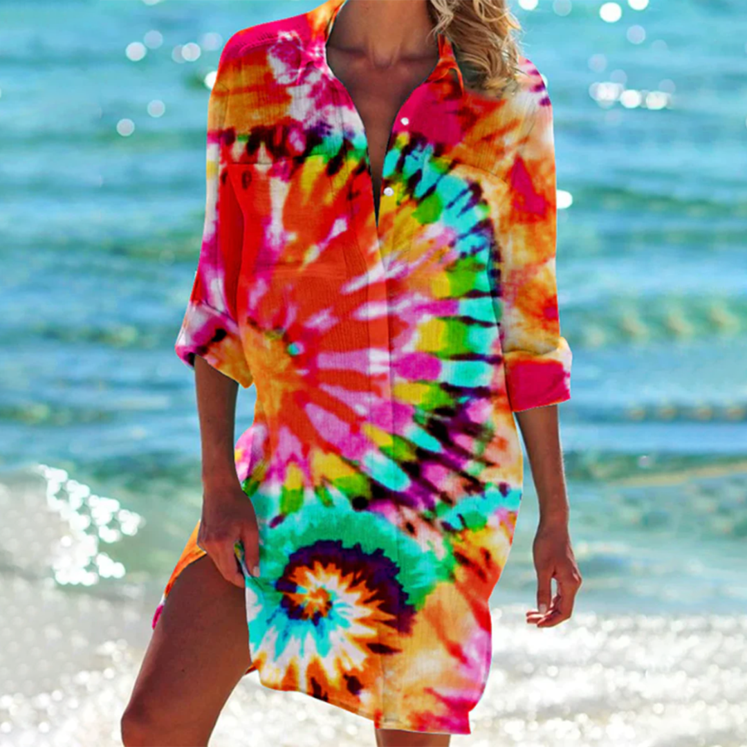 Person wearing a colorful tie-dye cover-up on a beach