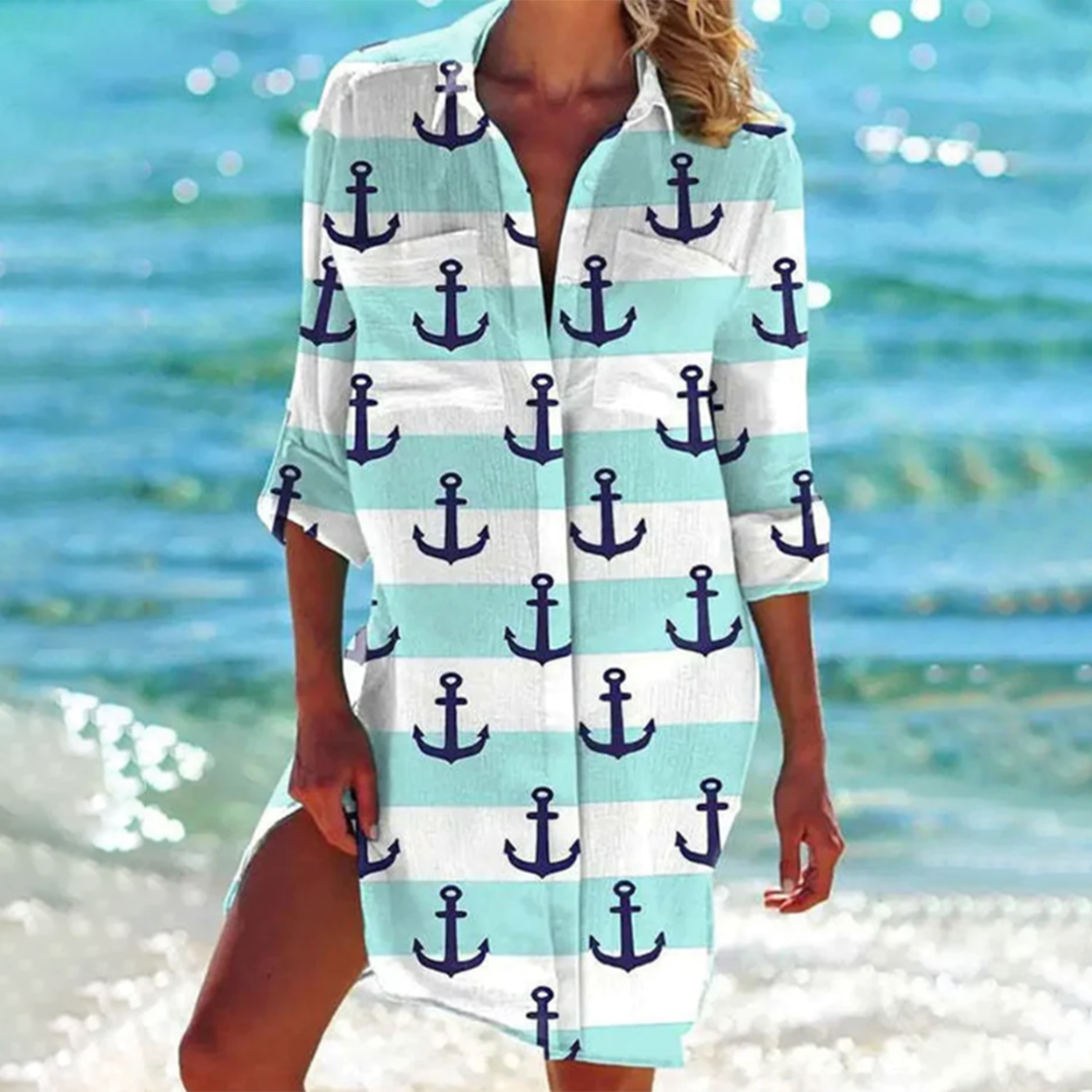 Person wearing a cover-up with anchor pattern by the beach