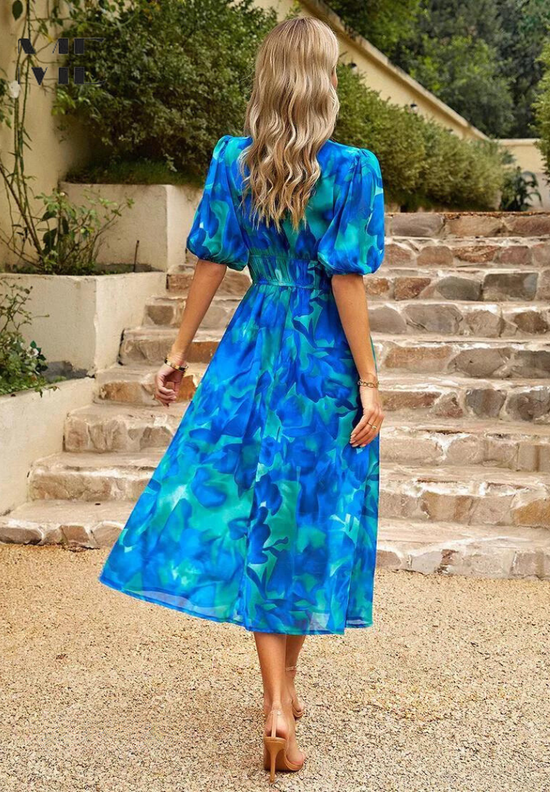 Woman in a blue floral dress walking up stone steps outdoors