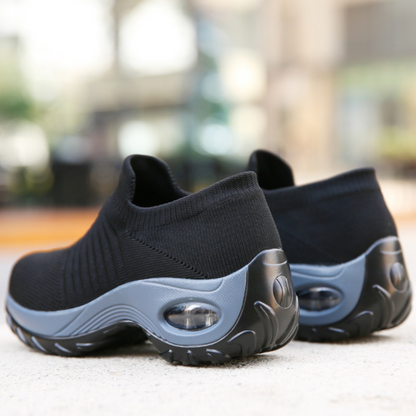 Black and gray slip-on shoes on a blurred outdoor background