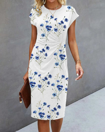 White dress with blue floral pattern worn by a person against a gray background