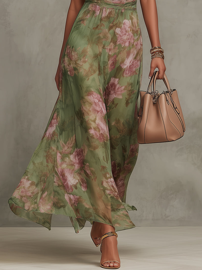 Woman wearing a green floral dress holding a beige handbag against a neutral background