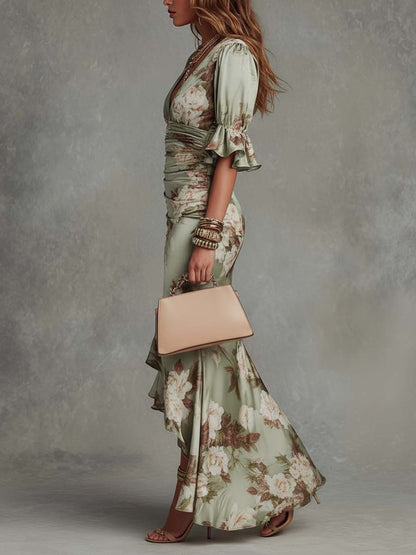 Woman in a floral dress holding a beige handbag against a gray background