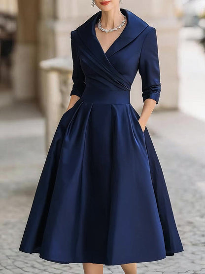 Navy blue dress with a fitted bodice and full skirt on a blurred street background
