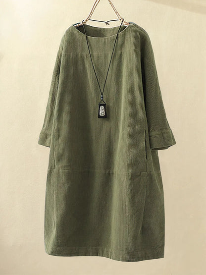 Green corduroy dress on a beige background