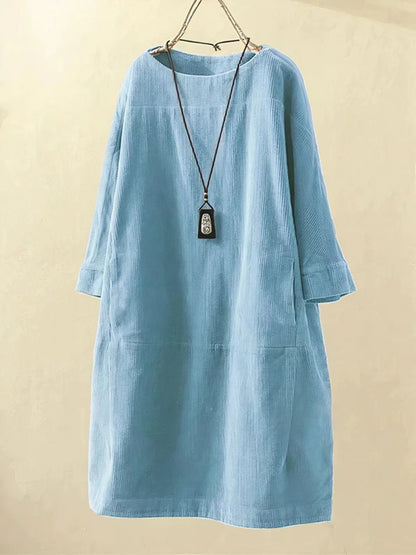 Light blue dress with a necklace on a beige background
