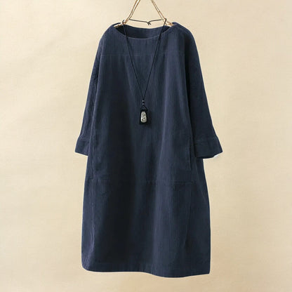Navy blue dress with a necklace on a beige background