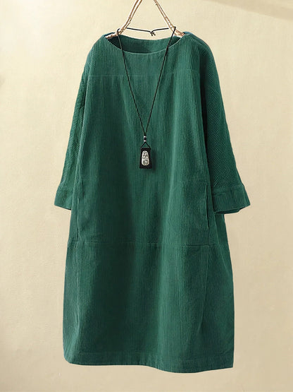 Green corduroy dress on a beige background