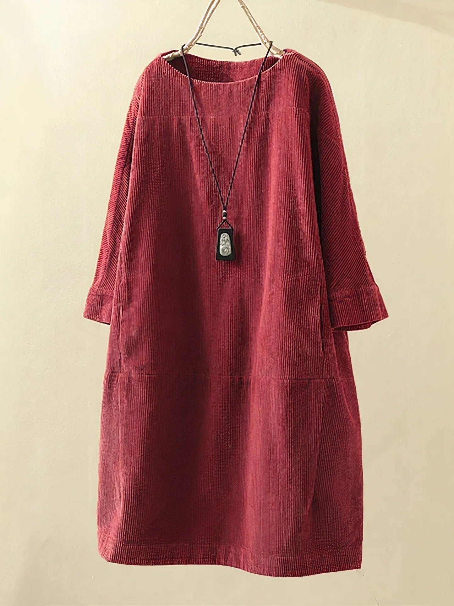 Red corduroy dress on a beige background