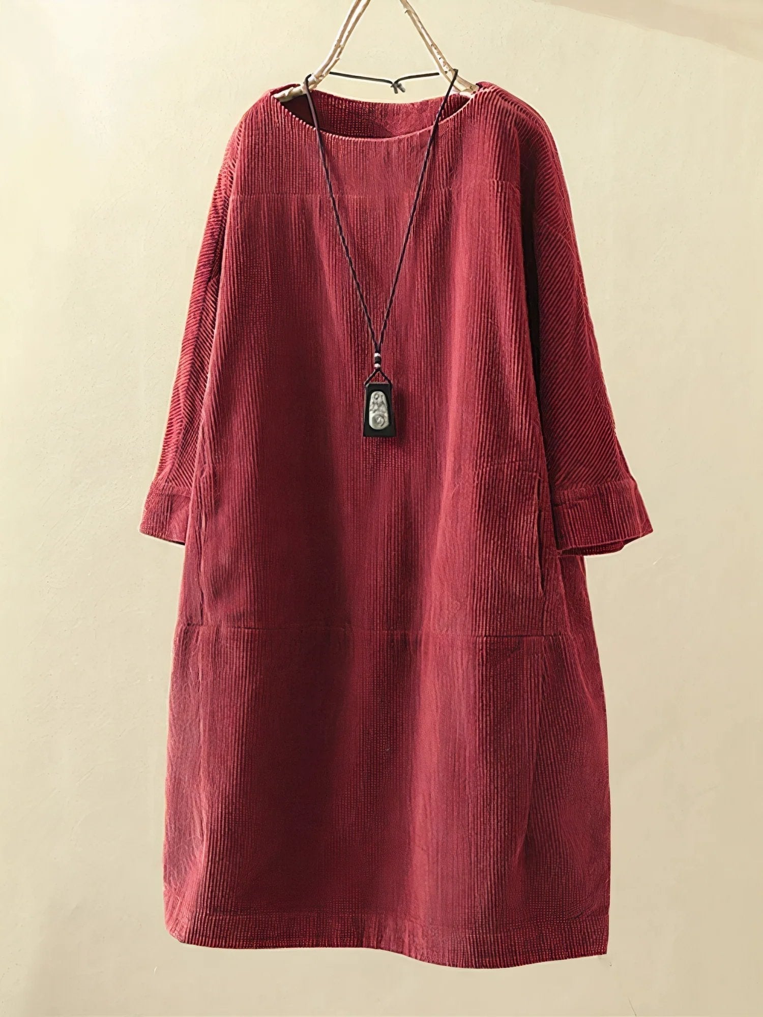 Red corduroy dress on a beige background