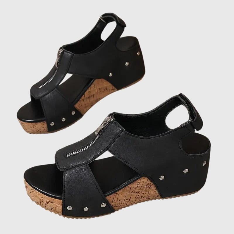 Black wedge sandals with cork sole on a light gray background