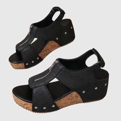 Black wedge sandals with cork sole on a light gray background