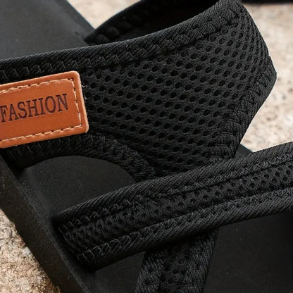 Black pet carrier with mesh design and 'FASHION' label on a textured surface
