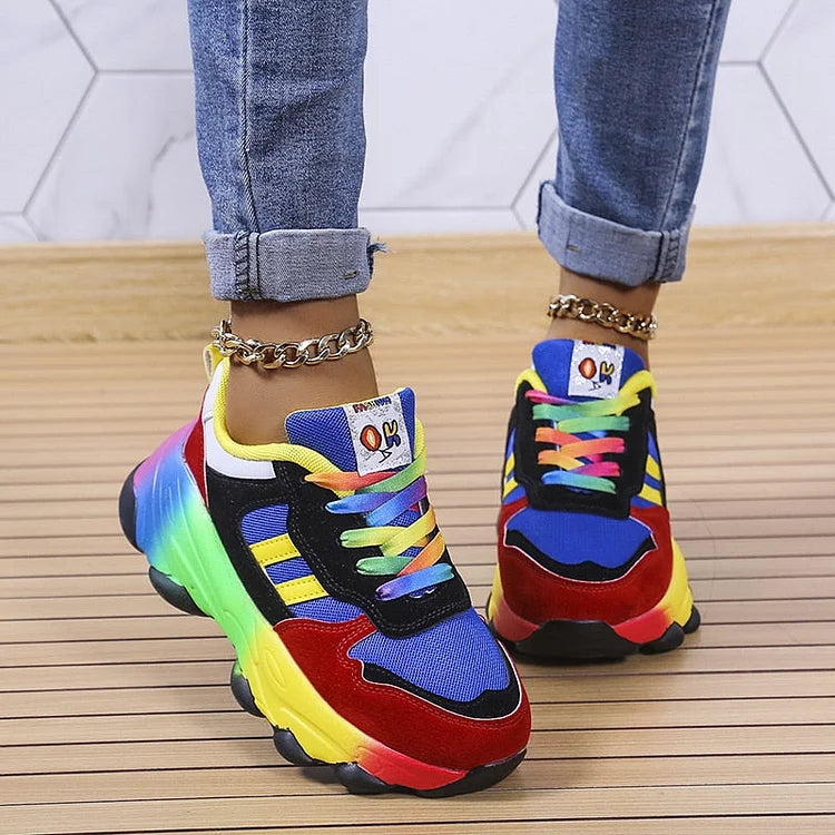 Colorful sneakers with a multicolor design worn on a wooden floor.