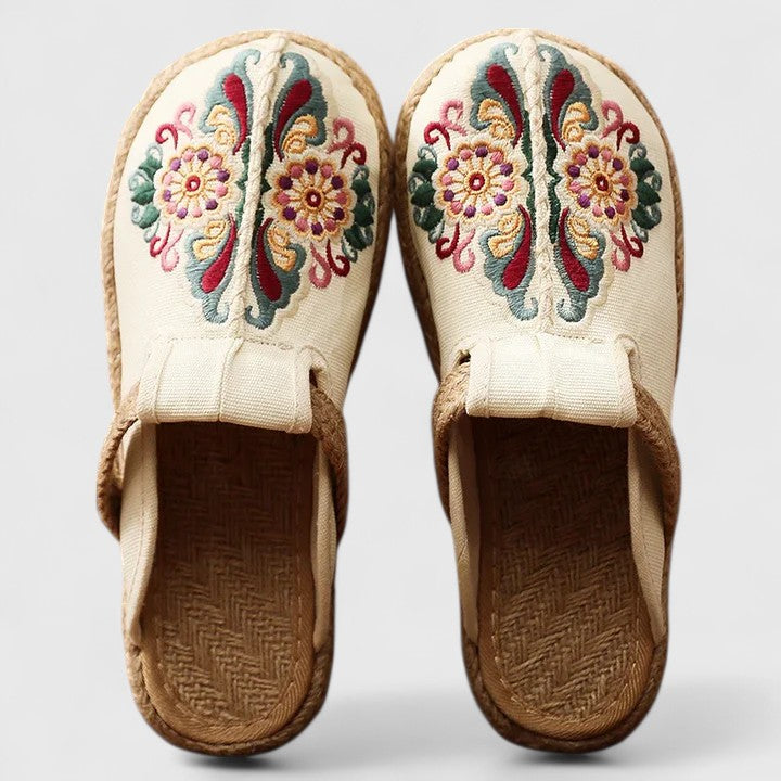 Pair of embroidered slippers with floral patterns on a light background