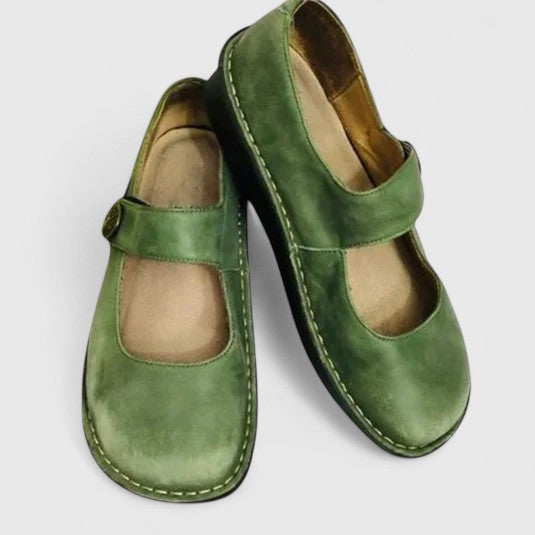 Pair of green shoes with velcro straps on a light gray background