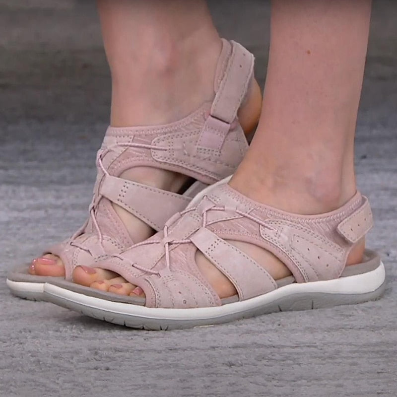 Pink sandals worn by a person on a gray surface