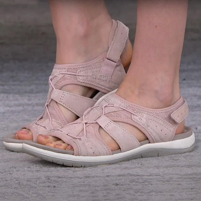 Pink sandals worn by a person on a gray surface