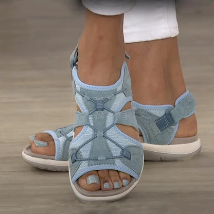 Blue sandals worn on feet with a neutral background