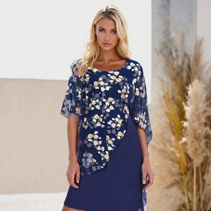 Woman wearing a navy floral dress standing in a neutral setting with decorative elements.