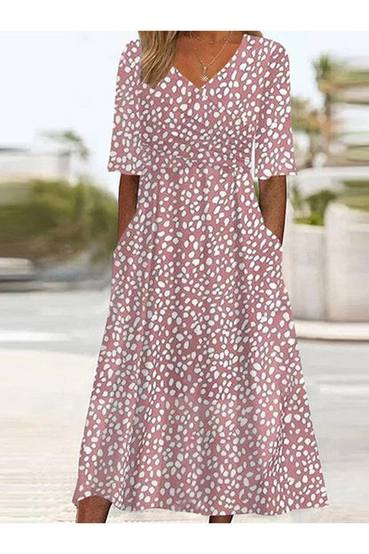 Woman wearing a pink floral dress with a blurred outdoor background