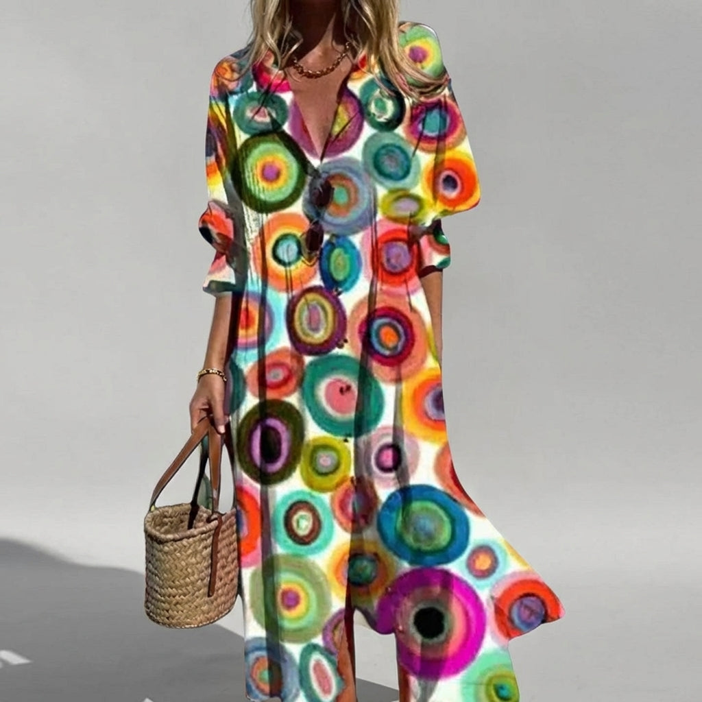 Woman wearing a colorful circular patterned dress on a gray background