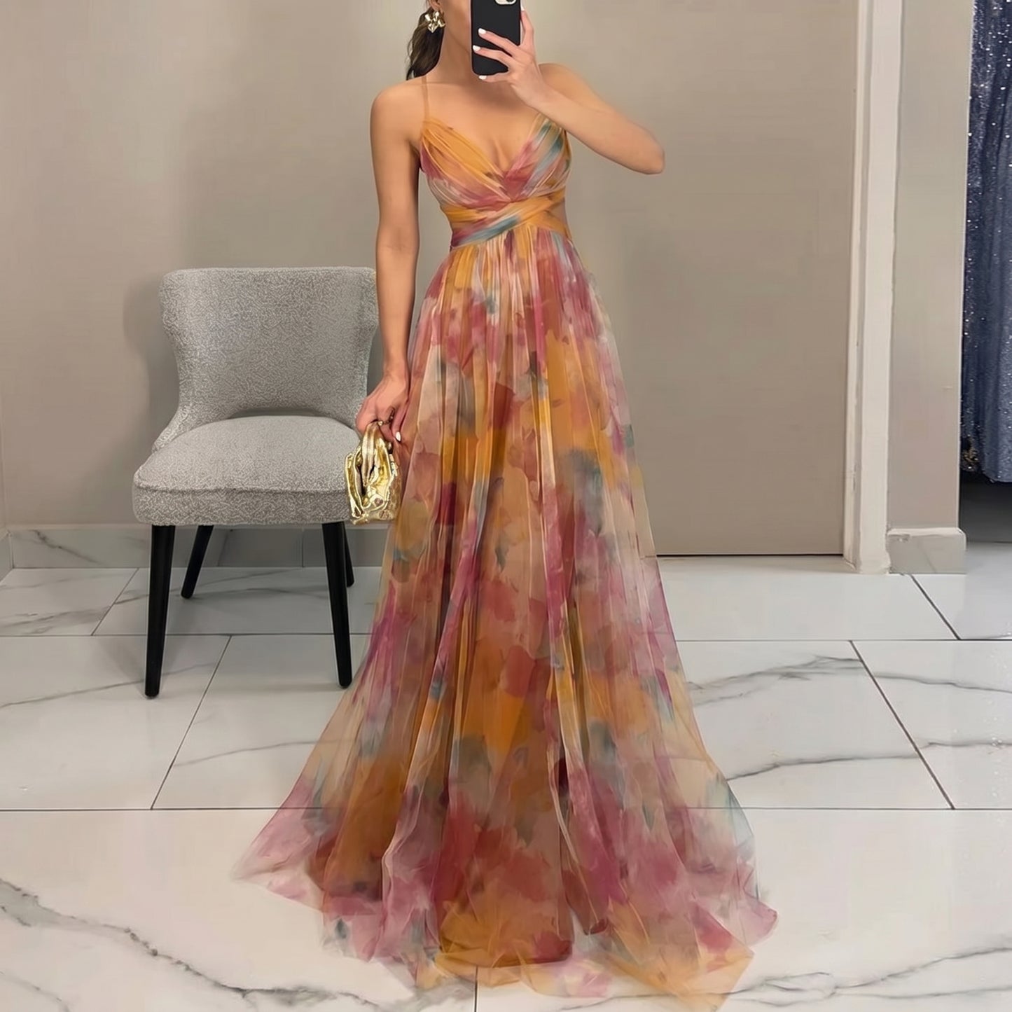 Woman in a colorful floral dress taking a mirror selfie in a room.