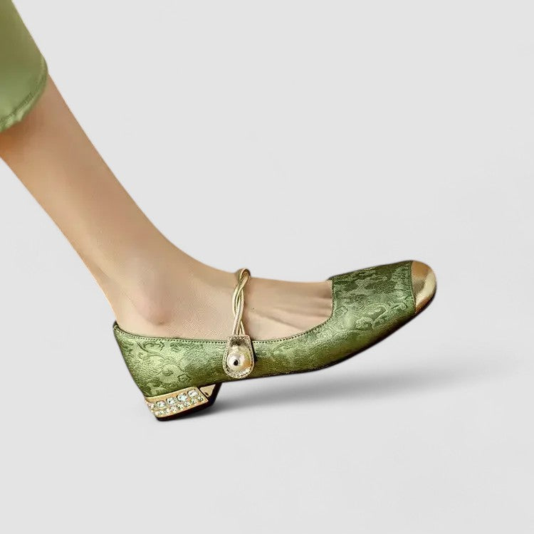 Green shoe with decorative elements on a light gray background